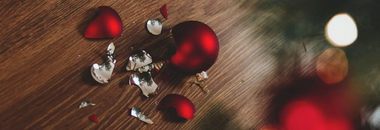 Zerbrochene Weihnachtsbaumkugel auf dem Fußboden.