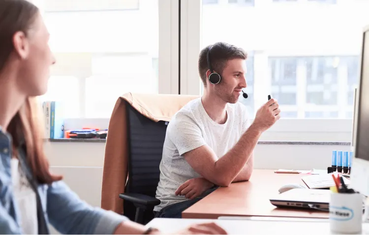 Mann mit Headset vor dem Bildschirm