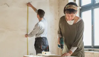 Mann und Frau renovieren ein Zimmer in einem Wohngebäude