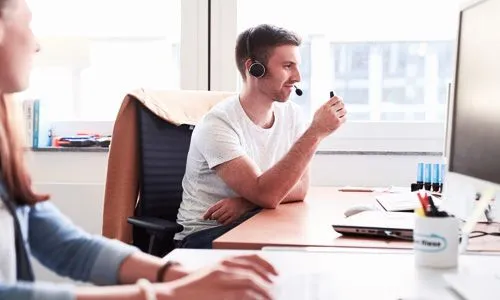 Tobi mit Headset am Schreibtisch