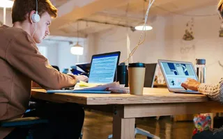 Zwei Personen arbeiten total konzentriert an ihren Laptops. 