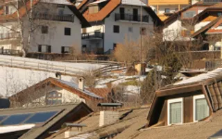 Ein herbstlich-winterlicher Blick über Häuserdächer mit Solaranlagen.